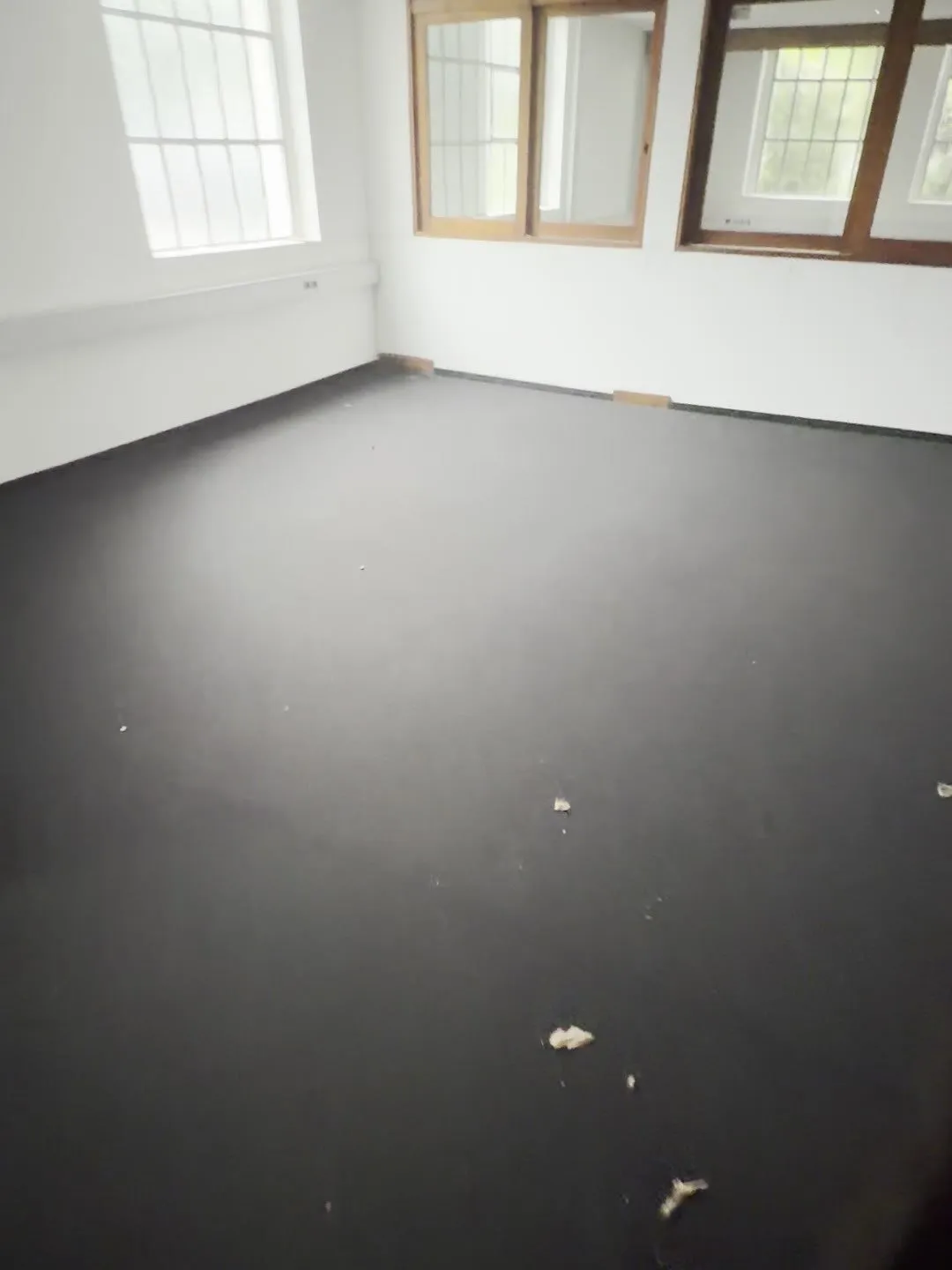 Büroraum vor dem Umbau mit dunklem, abgenutztem Teppichboden